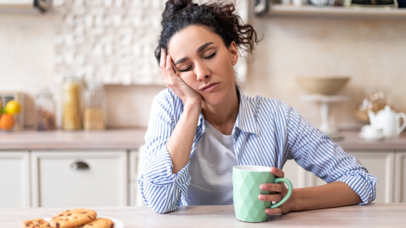 Tired woman holding coffee in the morning after poor sleep pressure buildup