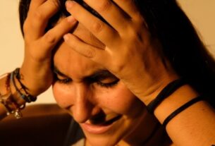 Person holding head during anxiety spikes and visible distress