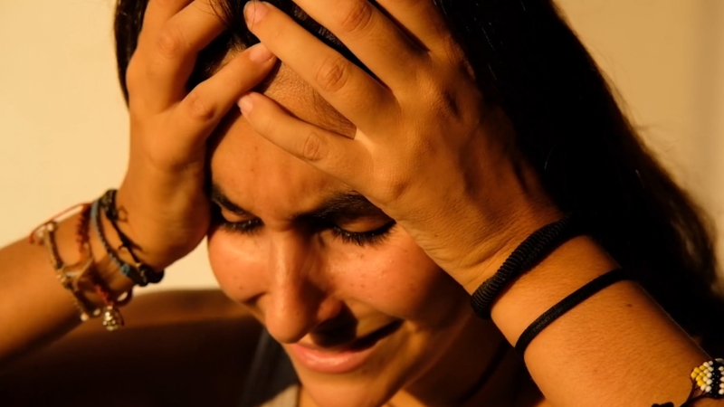 Person holding head during anxiety spikes and visible distress