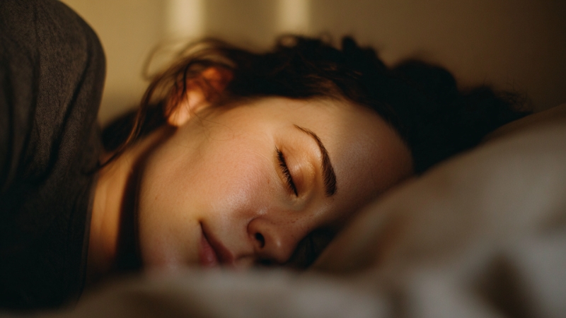Woman sleeping peacefully at night with a stable sleep schedule