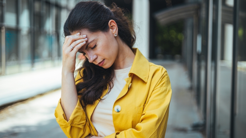 Woman holding her head in pain due to dehydration headache